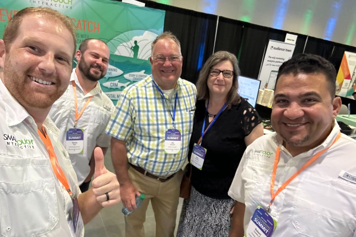 SmartTouch team at Sales and Marketing Leadership Summit in 2024. 4 Summit members smiling.