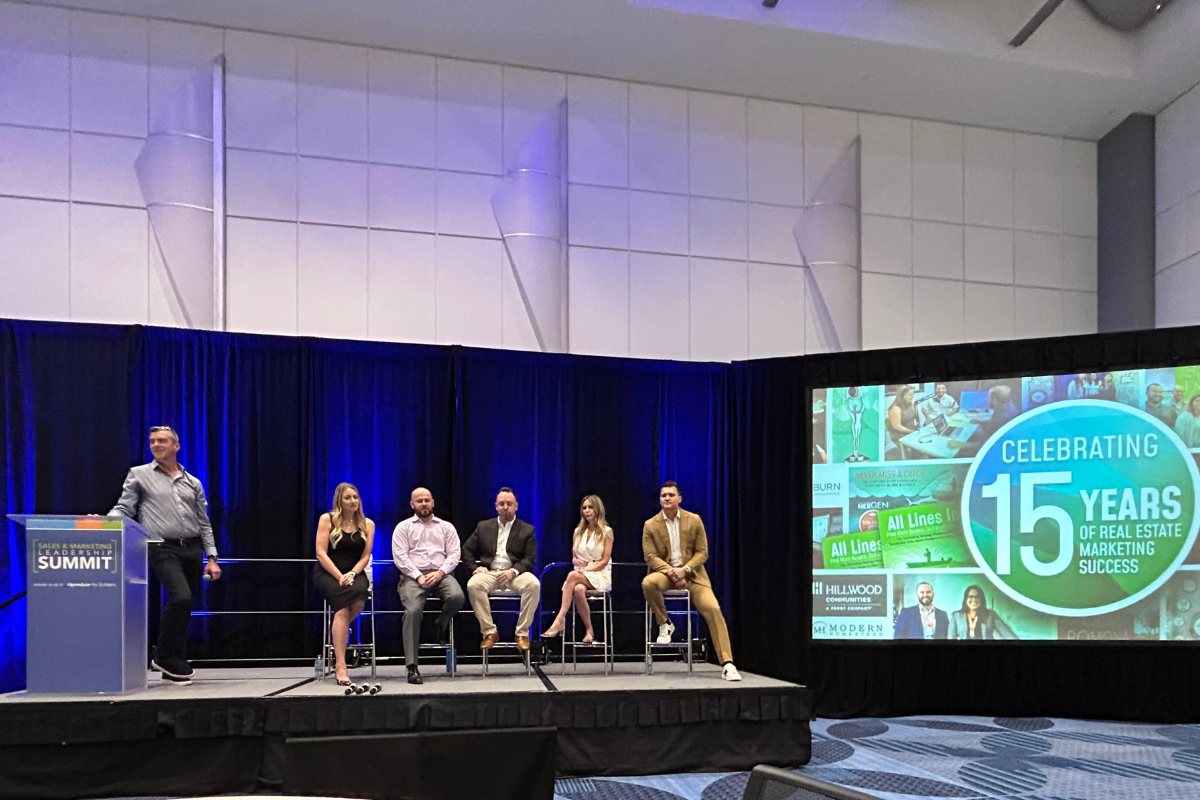 VP of Marketing, Tanner Ross, and panelists sitting on the panel stage.