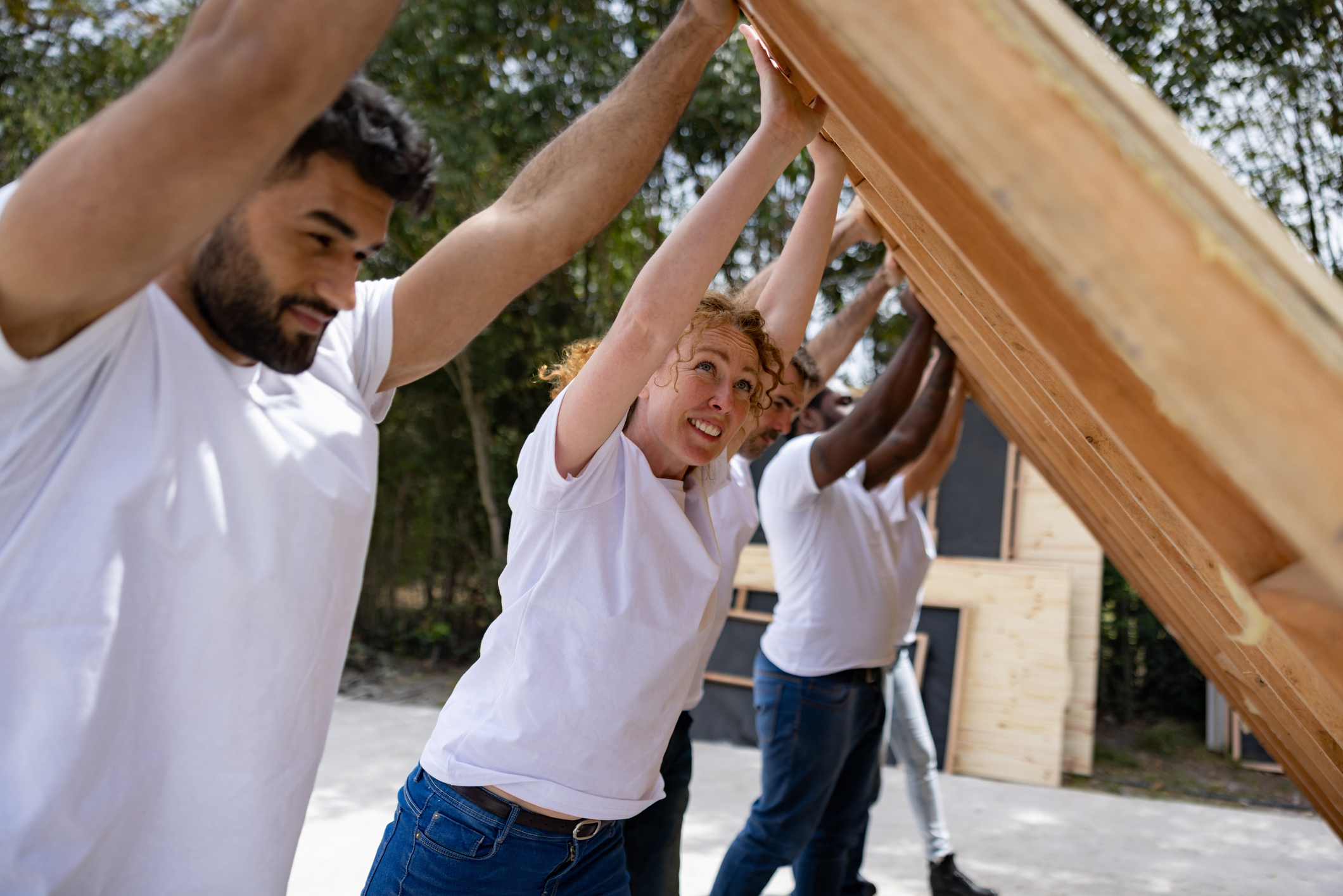 Group of people volunteering to build a house and working as a team - public housing project